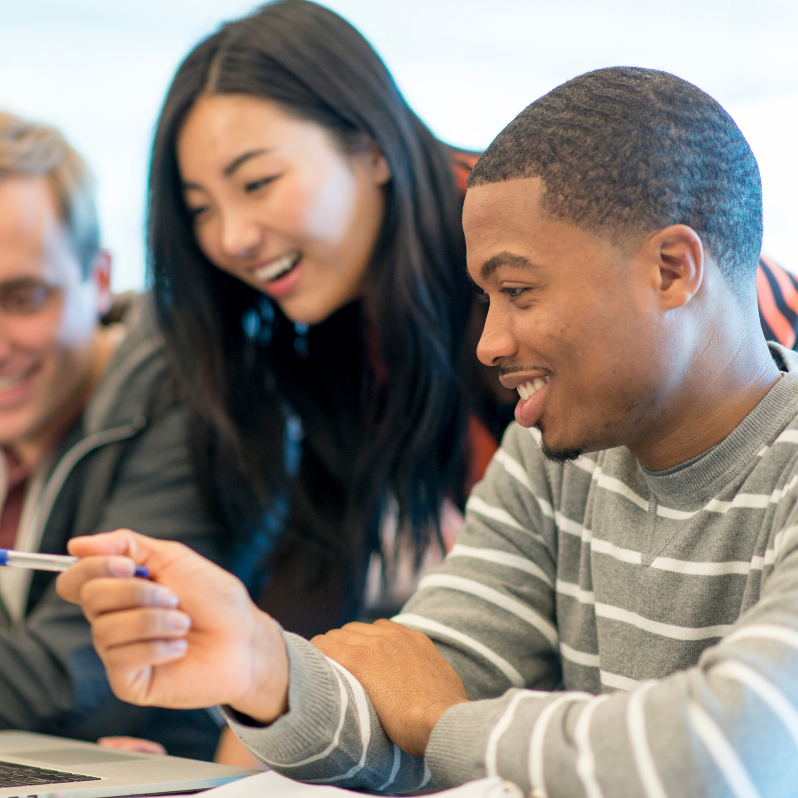 The image shows a group of students collaborating on a project