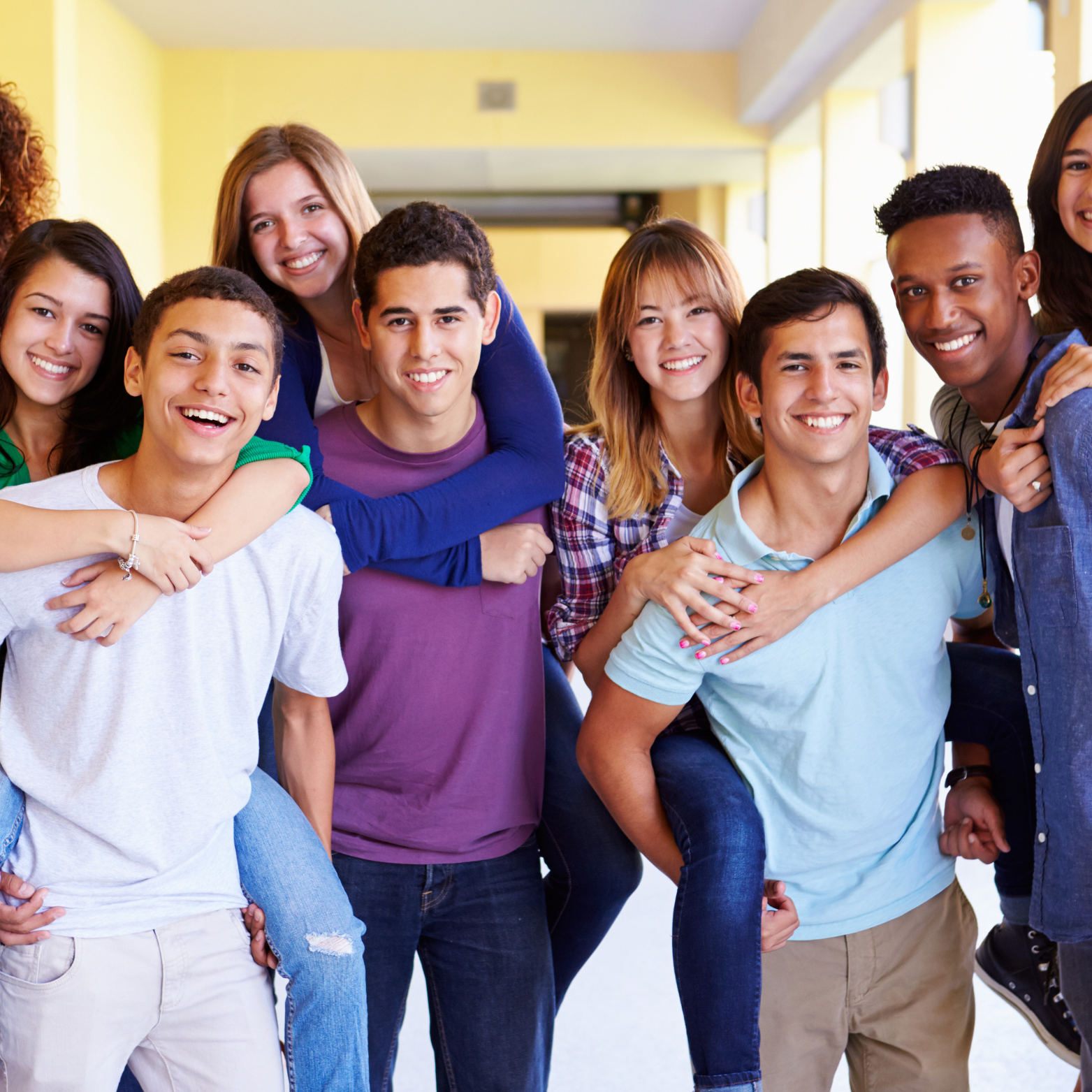 group of happy, smiling students embracing and posing together